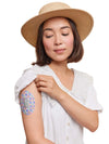 Woman wearing Dexcom G6 sensor patch with spring design on arm.
