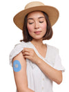 Dexcom G7 drop shape patch worn on a woman’s arm, with breathable adhesive fabric for sensor support