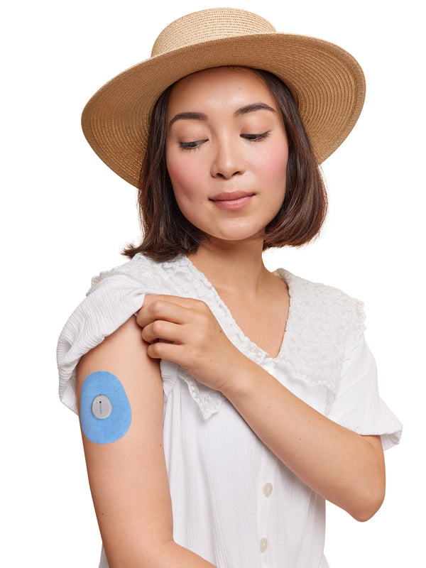Dexcom G7 drop shape patch worn on a woman’s arm, with breathable adhesive fabric for sensor support
