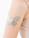 FreeStyle Libre 3 butterfly shape patch close-up on arm, showing breathable adhesive support around the sensor