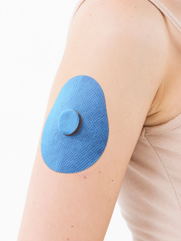 FreeStyle Libre 3 drop shape patch close-up on arm, showing breathable adhesive support around the sensor