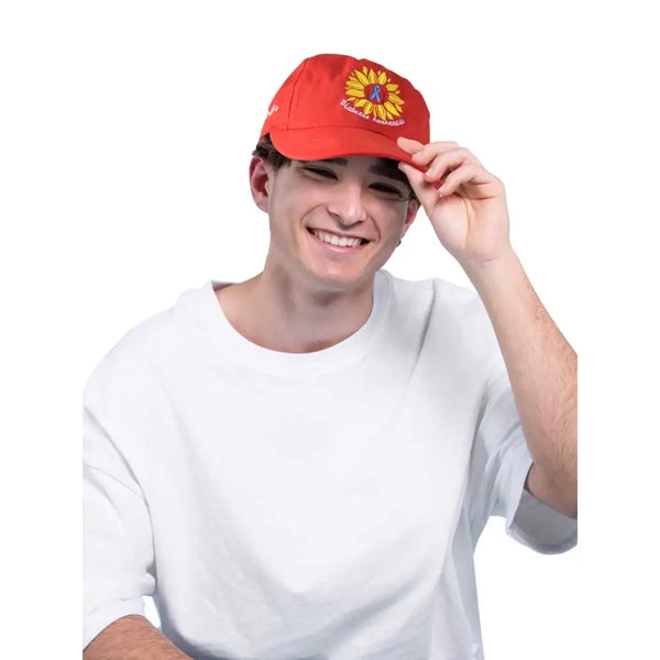 Red Kaio-Caps Diabetes Awareness Cap with sunflower emblem worn by smiling person.