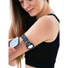 A woman using a smartphone app while wearing a Freestyle Libre 2 Armband with a patterned strap on her upper arm. The armband securely holds the sensor.
