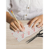 Insulin patch pump template being traced and cut for a personalized fit.