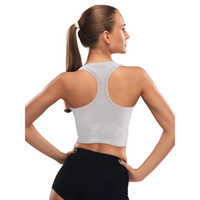 Woman wearing grey insulin pump adaptive crop top and black shorts, showcasing back and fit.