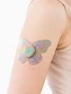 Dexcom G7 butterfly shape patch close-up on arm, showing breathable adhesive support around the sensor