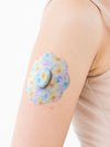 Dexcom G7 cookie shape patch close-up on arm, showing breathable adhesive support around the sensor