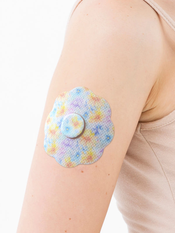 FreeStyle Libre 3 cookie shape patch close-up on arm, showing breathable adhesive support around the sensor