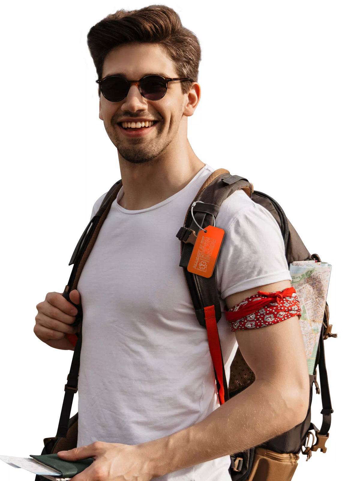 Man wearing sunglasses and a white shirt, carrying a backpack with an orange medical luggage tag attached.