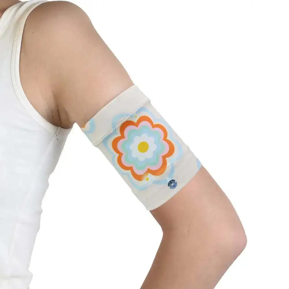 Protective armband for glucose sensor with colorful flower design worn on upper arm